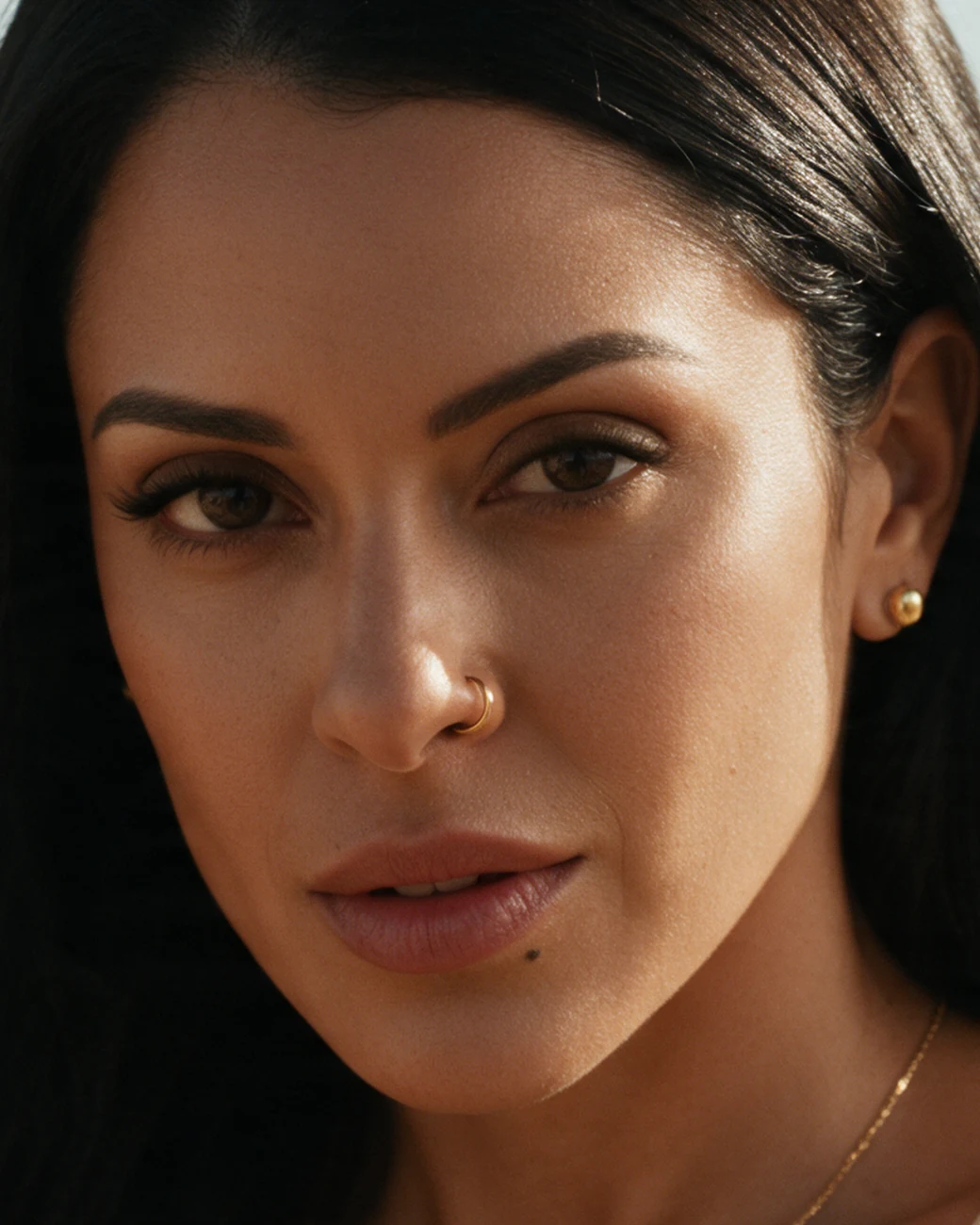 Her face, close, in warm light, looking straight ahead.